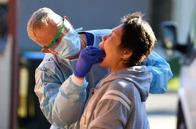 A nurse conducts swab tests for COVID-19 after people displayed cold and flu symptoms, at a private residence in Hallam, Melbourne, Australia, 01 July 2020. Victoria has recently witnessed a spike in coronavirus infections. (Photo by James Ross/EPA/EFE)