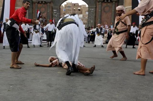 A Houthi follower lies on the ground, resempling a victim, as others perform a war dance during a ceremony marking the first anniversary of the Houthi movement's takeover of Yemen's capital Sanaa September 21, 2015. (Photo by Khaled Abdullah/Reuters)