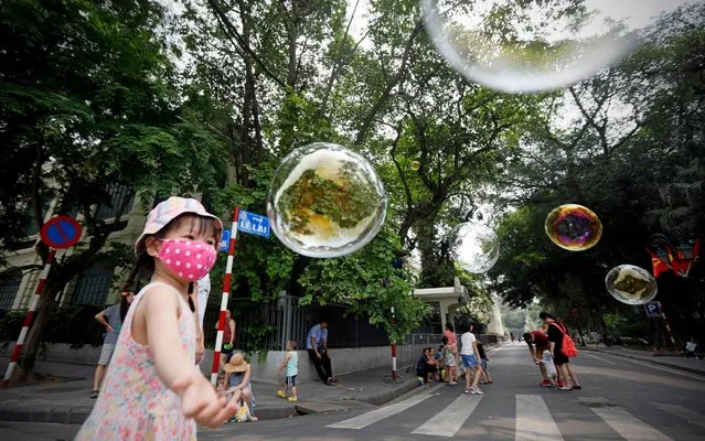 A kid plays with soap bubbles at a pedestrian street around Hoan Kiem lake in Hanoi, Vietnam 17 May 2020. Hanoi reopened many tourist attractions after a long shutdown due to the COVID-19 disease pandemic. Several countries around the world have started to ease COVID-19 lockdown restrictions in an effort to restart their economies and help people in their daily routines after the outbreak of coronavirus pandemic. (Photo by Luong Thai Linh/EPA/EFE/Rex Features/Shutterstock)