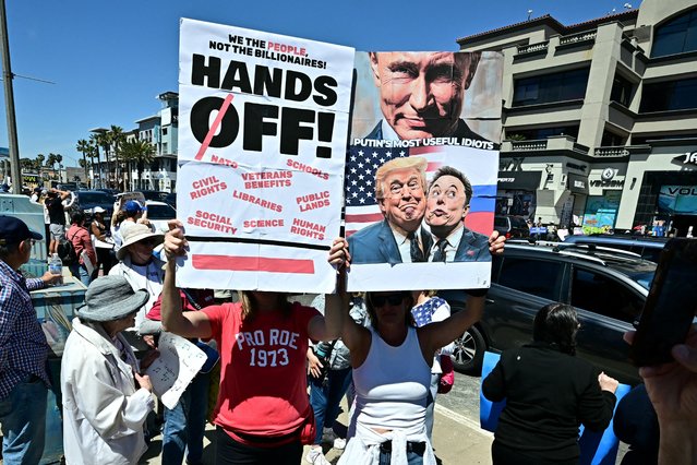 Protestors gather during a “Hands Off!” protest against the policies of US President Donald Trump and his advisor, Tesla CEO Elon Musk, in Huntington Beach, California, on April 5, 2025. Thousands of people descended on Washington's National Mall and rallied in other cities across the United States and abroad in opposition to the policies of Donald Trump, in the largest protests since he returned to the presidency. (Photo by Frederic J. Brown/AFP Photo)