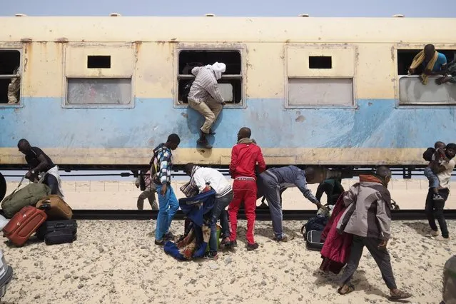 Passengers on a SNIM train carrying iron ore and mine workers arrive in Nouadhibou June 25, 2014. (Photo by Joe Penney/Reuters)