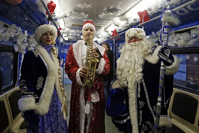 Passengers dressed as the Snowmaid, Santa, and Father Frost travel on a seasonally themed train on the Moscow Underground in Moscow, Russia on December 25, 2017. (Photo by Alexander Shcherbak/TASS)