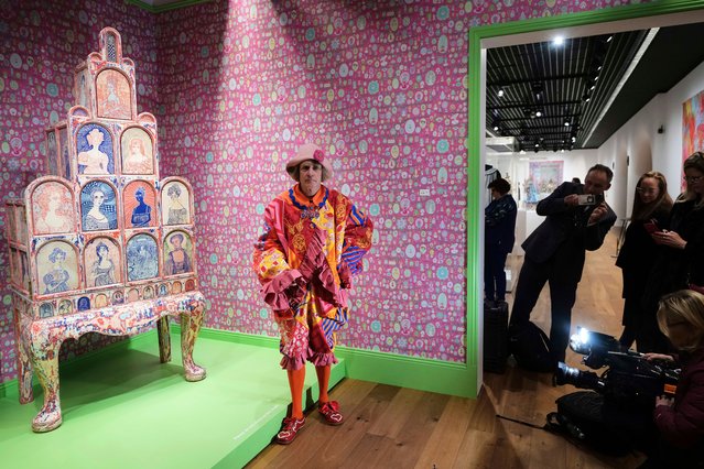Artist Sir Grayson Perry poses in front of one of his artworks on display at his exhibition called Grayson Perry: Delusions of Grandeur which includes ceramics, tapestries, furniture and collage at The Wallace Collection in London, Tuesday, March 25, 2025. (Photo by Kirsty Wigglesworth/AP Photo)