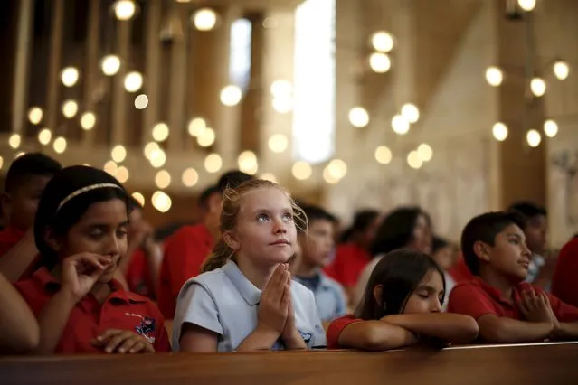 Ruby Park, 11, (2nd L) listens to Pope Francis celebrating the Canonization Mass for Friar Junipero Serra in Washington on a television screen in Los Angeles, California, United States, September 23, 2015. (Photo by Lucy Nicholson/Reuters)
