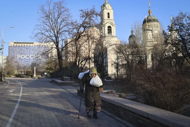 An elderly woman walks down a street central Donetsk, the capital of Russian-controlled Donetsk region, eastern Ukraine, Thursday, December 15, 2022. (Photo by Alexei Alexandrov/AP Photo)