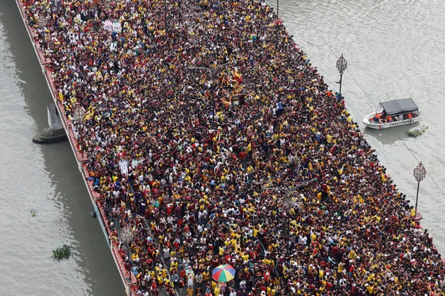 Devotees flock as a carriage bearing an image of Black Nazarene makes its way through the Jones bridge in Manila, Philippines, January 9, 2018. (Photo by Erik De Castro/Reuters)