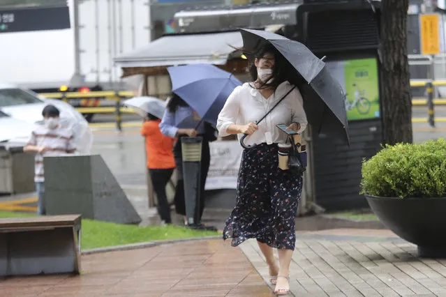 A woman holds an umbrella against the strong wind and rain caused by Typhoon Bavi in Seoul, South Korea, Thursday, August 27, 2020. Typhoon Bavi that grazed South Korea and caused some damage has made landfall in North Korea early Thursday. South Korean authorities said there were no immediate reports of casualties, and North Korea has not reported any damages. (Photo by Ahn Young-joon/AP Photo)