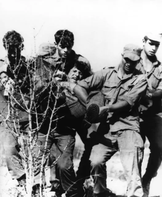 Israeli troops carry a squatter from a site near Joricho north of the Dead Sea in the occupied West Bank of Jordan on Wednesday, October 9, 1974. Rightwing groups attempted to establish settlement in the area in advance of U.S. Secretary of State Henry Kissinger's visit. The squatters hoped to influence possible negotiations of territory with Jordanians. (Photo by Max Nash/AP Photo)