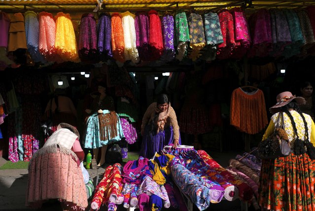 A “chola” skirt vendor makes offers to prospective buyers in El Alto, Bolivia, November 25, 2024. (Photo by Juan Karita/AP Photo)