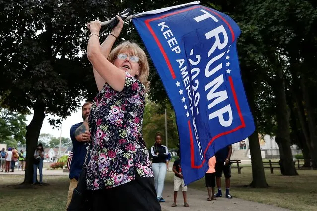 U.S. President Donald Trump supporter waves a flag at Civic Center Park during his visit in Kenosha, Wisconsin, U.S., September 1, 2020. (Photo by Kamil Krzaczynski/Reuters)