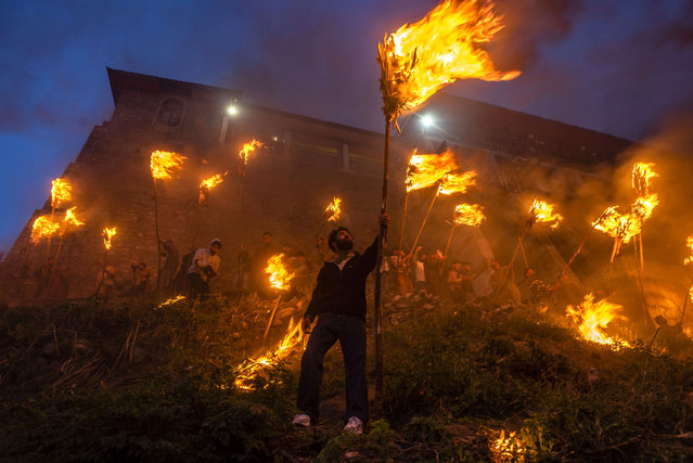 Kashmiri Muslims hold burning torches outside the cave shrine of Sakhi Zain-ud-din Wali, a Sufi saint, during an annual torch festival on April 12, 2025 in Aishmuqam, south of Srinagar, India. Thousands of Kashmiri Muslims gathered at the shrine of Sheikh Zainuddin Wali in Aishmuqam, south Kashmir, to celebrate the annual Urs and torch festival. The event, rooted in Sufi tradition, marks the end of winter and the beginning of the sowing season. A torchlight procession, known as Frove, was held at sunset, with devotees from nearby villages taking part. The procession symbolizes the victory of good over evil. For many farmers in the region, visiting the shrine is seen as an auspicious start to agricultural activities. The celebrations also featured traditional folk music and devotional songs. (Photo by Yawar Nazir/Getty Images)