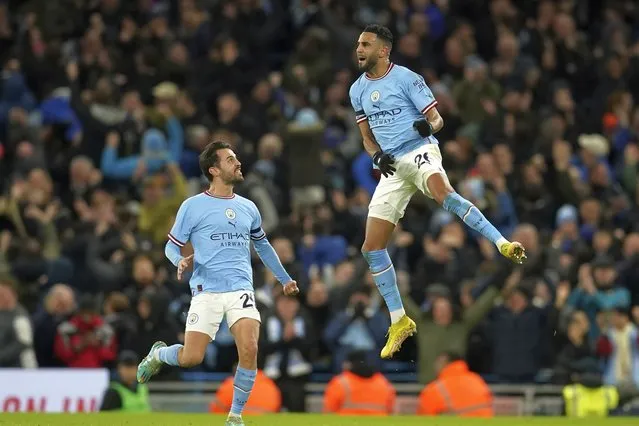 Manchester City's Riyad Mahrez, right, leaps in the air to celebrate his side's opening goal during the English FA Cup soccer match between Manchester City and Chelsea at the Etihad Stadium in Manchester, England, Sunday, January 8, 2023. (Photo by Dave Thompson/AP Photo)