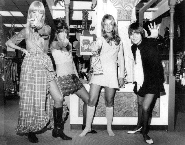 British fashion designer Mary Quant, right, waves as she poses with models, from left, from left, are, Amanda Tear, Rory Davis and Penny Yates, wearing her Mod creations in Little Rock, Ark. on October 25, 1968. Quant, the designer whose fashions epitomized the Swinging 60s, has died at the age of 93. Quant's family said she died “peacefully at home” in Surrey, southern England, on Thursday, April 13, 2023. (Photo by AP Photo, File)