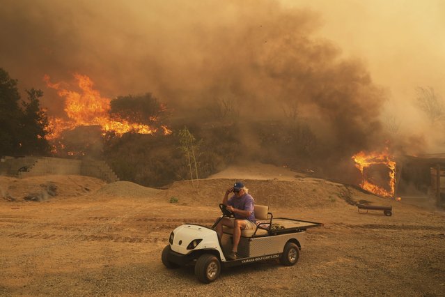 A resident rides a golf cart as he exits his property while the Canyon Fire burns on Thursday, August 7, 2025, in Halsey Canyon, Calif. (Photo by Marcio Jose Sanchez/AP Photo)