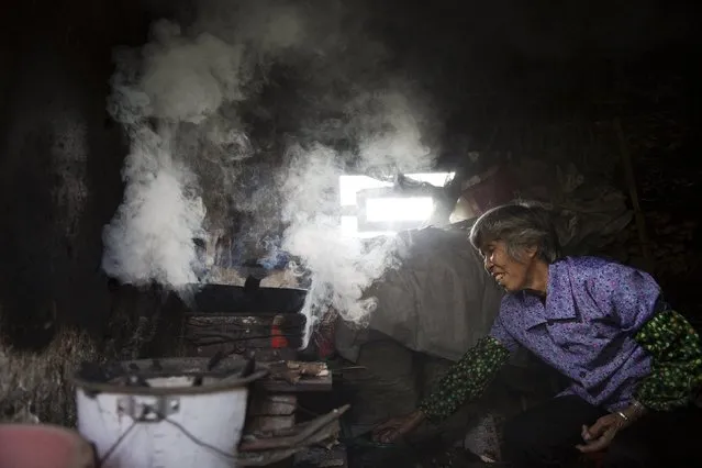 Wang Ninde, whose husband is a former miner suffering from pneumoconiosis, prepares lunch at a makeshift kitchen in Yangjia Hospital in Wuyi County, Zhejiang Province, China October 19, 2015. (Photo by Damir Sagolj/Reuters)