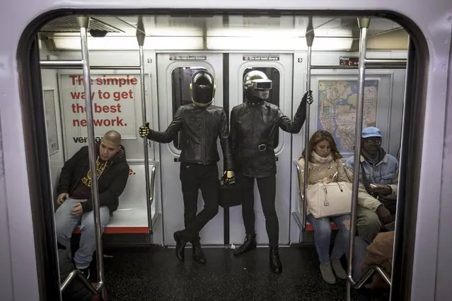 A couple dressed up as musical act Daft Punk ride the shuttle subway at Times Square station in the Manhattan borough of New York October 31, 2015. (Photo by Carlo Allegri/Reuters)