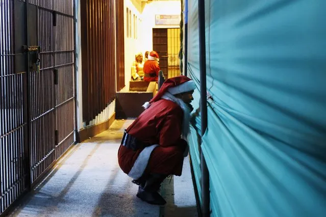 An inmate dressed as Santa Claus watches an event backstage ahead of Christmas celebrations at Santa Monica female prison in Lima December 19, 2014. (Photo by Enrique Castro-Mendivil/Reuters)