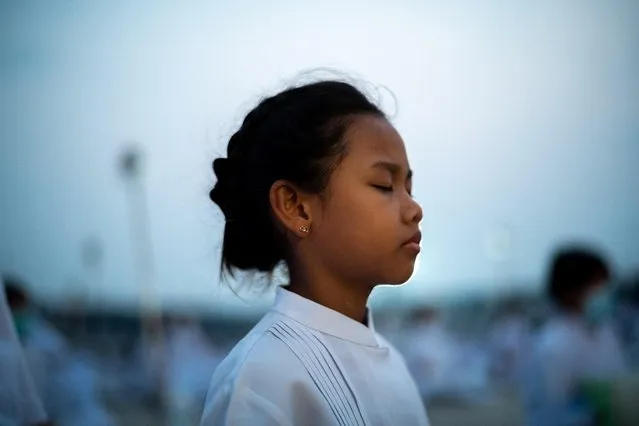 A girl prays at the Wat Phra Dhammakaya temple during a ceremony commemorating Makha Bucha Day in Pathum Thani province outside Bangkok, Thailand on March 6, 2023. (Photo by Athit Perawongmetha/Reuters)