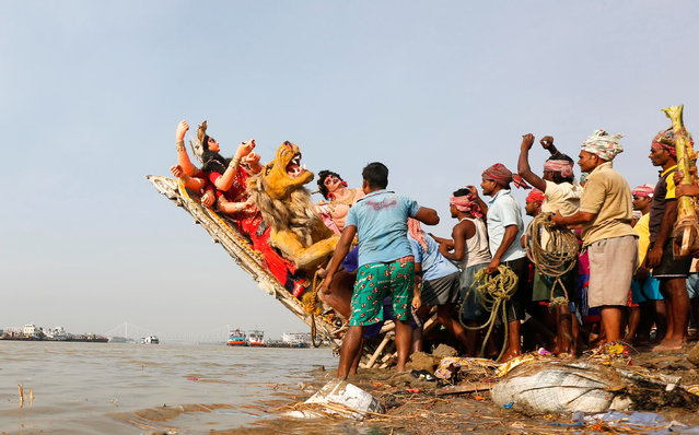 Devotees immerse an idol of the Hindu goddess Durga into the Ganges river after the end of the Durga Puja festival in Kolkata, India, October 13, 2016. (Photo by Rupak De Chowdhuri/Reuters)
