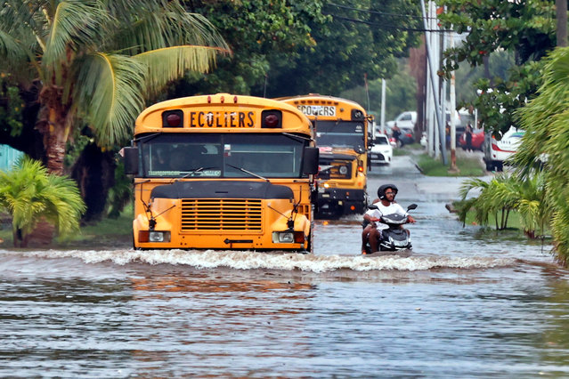 School buses pass through a flooded street after heavy rains in Havana, Cuba, 12 August 2025. (Photo by Ernesto Mastrascusa/EPA)