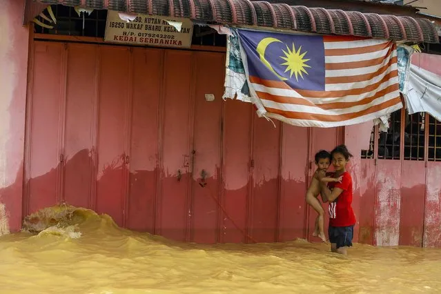 Girls playing in floodwater in the Tendong district of Kelantan, Malaysia, 28 December 2014. (Photo by Azhar Rahim/EPA)