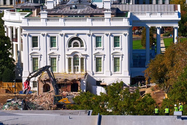Construction workers, bottom right, atop the U.S. Treasury, watch watch as demolition continues on the East Wing of the White House to make room for a new ballroom, in Washington, October 22, 2025. (Photo by Jacquelyn Martin/AP Photo)