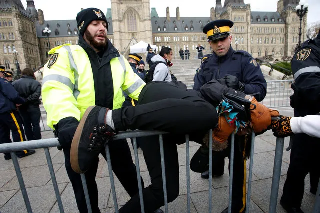 A protestor struggles to cross a police barricade during a demonstration against the proposed Kinder Morgan pipeline on Parliament Hill in Ottawa, Ontario, Canada, October 24, 2016. (Photo by Chris Wattie/Reuters)