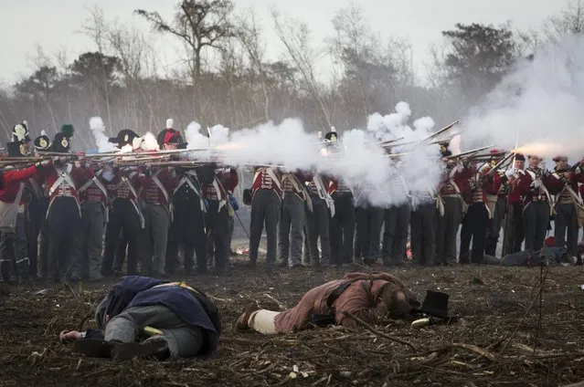 Reenactors playing the roll of British soldiers fire muskets at United States fighters, with fallen men in the foreground, during a reenactment of the Battle of New Orleans in the War of 1812, marking its bicentennial in Chalmette, Louisiana January 10, 2015. (Photo by Lee Celano/Reuters)