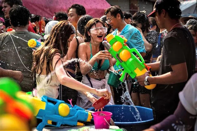 A Songkran Party goer shrieks as she is hit with spray from a water gun on Khaosan Road on April 13, 2023 in Bangkok, Thailand. Songkran, the traditional Thai New Year's Festival, is celebrated each April, Thailand's hottest month of the year. During Songkran, locals and tourists celebrate by partaking in water fights throughout the country. (Photo by Lauren DeCicca/Getty Images)