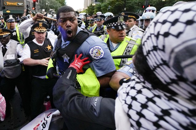 Demonstrators clash with police near the Israeli Consulate during the Democratic National Convention in Chicago, August 20, 2024. (Photo by Julio Cortez/AP Photo)