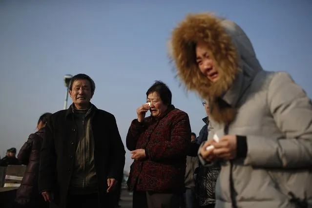 Relatives of a person missing after a tug boat sank, mourn on the bank of the Yangtze River, near Jingjiang, Jiangsu province January 17, 2015. (Photo by Aly Song/Reuters)