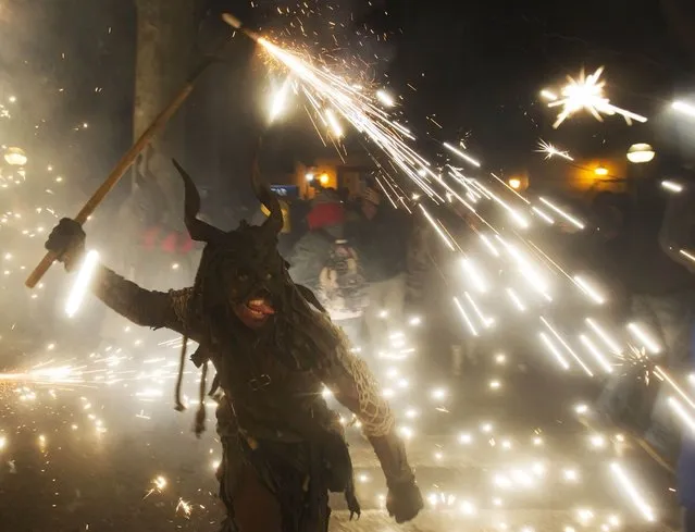 A reveller wearing a demon costume takes part in the traditional festival of “Correfoc” in Palma de Mallorca, on January 17, 2015. The Correfoc is a night of revelry in which participants dress as demons and devils, and move through the streets scaring people with fire and fireworks. (Photo by Jaime Reina/AFP Photo)