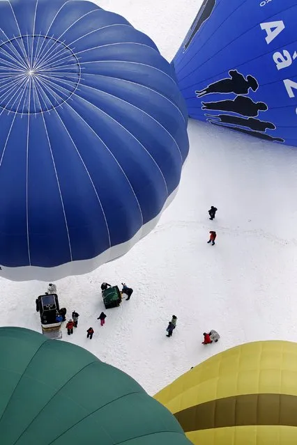 Balloons of all shapes and sizes get ready for take off at the 37th International Hot Air Balloon Week in Chateau-d'Oex, January 24, 2015. (Photo by Pierre Albouy/Reuters)