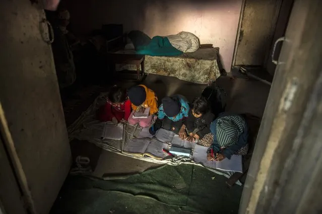 Children study by the light coming in through the entrance of the room during a power shortage at their house on Margalla Hills in Islamabad January 22, 2015. (Photo by Zohra Bensemra/Reuters)