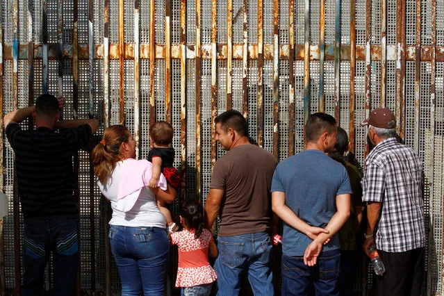 People talk to their relatives across a fence separating Mexico and the United States, in Tijuana, Mexico, November 12, 2016. (Photo by Jorge Duenes/Reuters)