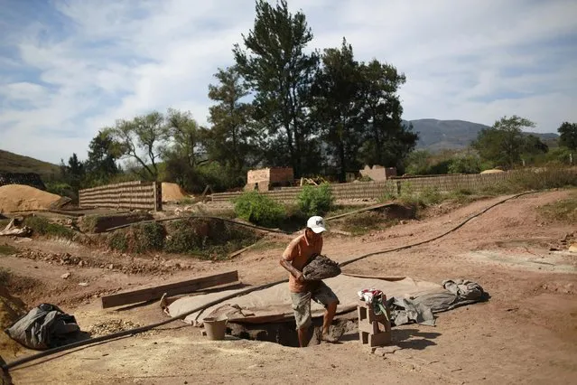 A worker exits a hole as he carries mud used to make bricks at a brick factory in Tixtla, on the outskirts of Chilpancingo, in the Guerrero state, January 26, 2015. (Photo by Jorge Dan Lopez/Reuters)