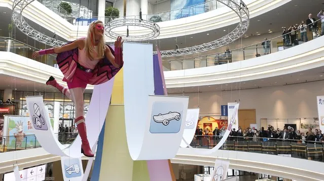 A young woman, dressed as a “Barbie” doll, poses in the air as she hangs from a ceiling, during the press preview of the 66th International Toy Fair in Nuremberg January 27, 2015. More than 2,700 exhibitors from over 60 countries worldwide will present their new toy products from January 28 to February 2, 2015. (Photo by Michaela Rehle/Reuters)