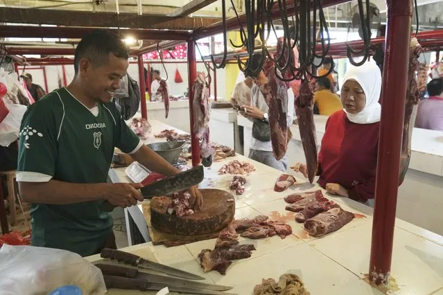 A butcher serves a customer at a market in Jakarta, Indonesia, Wednesday, March 22, 2023. Millions of Muslims in Indonesia are preparing to welcome the holy month of Ramadan, which is expected to start on Thursday, with traditions and ceremonies in the world's largest Muslim-majority country amid soaring food prices. (Photo by Ahmad Ibrahim/AP Photo)