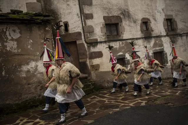 In this photo taken on Tuesday, January 27, 2015 Joaldunaks, some to call them “Zanpantzar”, take part on the Carnival between of the Pyrenees villages of Ituren and Zubieta, northern Spain. The Pyrenees villages of Ituren and Zubieta stage one of Europe’s most ancient carnivals – dating from Roman times – where residents dress up as figures known as “Joaldunak”, – or cowbells – and parade the streets with sheepskins around the waist and shoulder, conical caps and cowbells on their back. (Photo by Alvaro Barrientos/AP Photo)