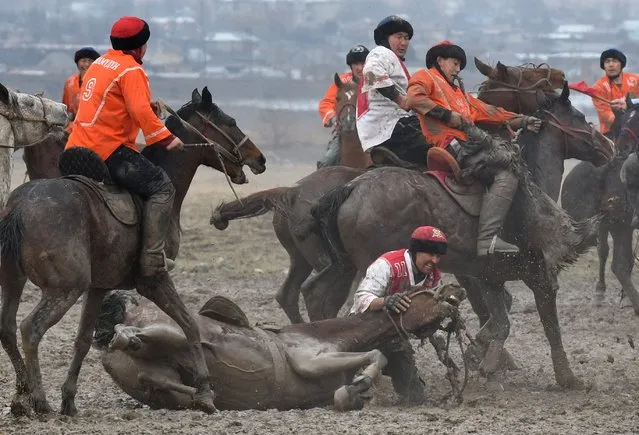 Kyrgyz riders play the traditional Central Asian sport of Kok-Boru (Gray Wolf) or Buzkashi (Goat Grabbing) in the village of Sokuluk, some 20 kilometres from Bishkek, on March 30, 2021. Kok-Boru is a traditional horse game where mounted players compete for points by manoeuvering a stuffed sheepskin into the opponents goalpost. (Photo by Vyacheslav Oseledko/AFP Photo)