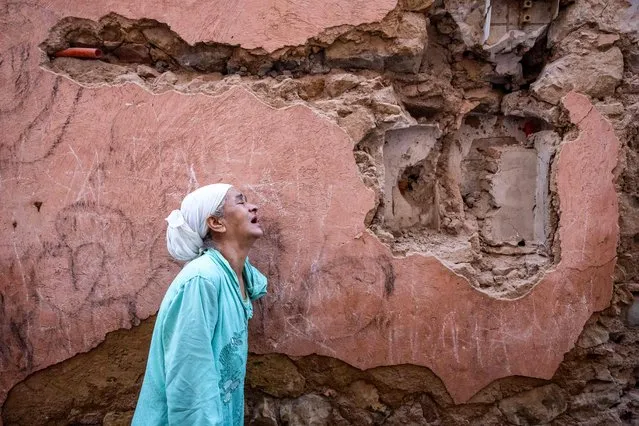 A woman reacts standing infront of her earthquake-damaged house in the old city in Marrakesh on September 9, 2023. A powerful earthquake that shook Morocco late September 8 killed more than 600 people, interior ministry figures showed, sending terrified residents fleeing their homes in the middle of the night. (Photo by Fadel Senna/AFP Photo)