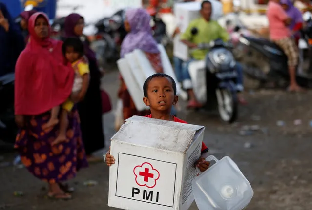 A boy  carrying an aid package leaves a temporary shelter at a mosque following this week's strong earthquake in Meureudu,  Pidie Jaya, Aceh province, Indonesia December 10, 2016. (Photo by Darren Whiteside/Reuters)