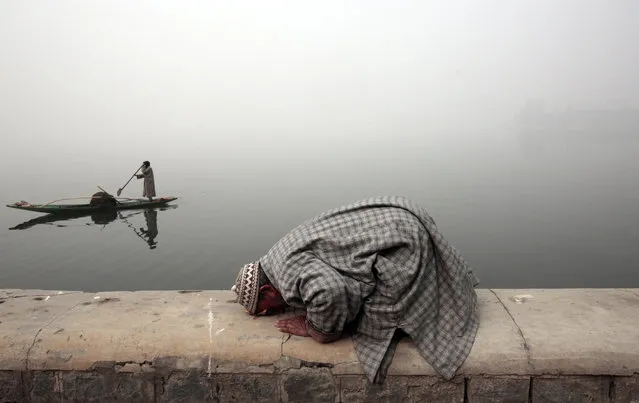 A Kashmiri Muslim man offers prayers on the banks of Dal Lake, during a cold and foggy day in Srinagar, the summer capital of Indian Kashmir, 10 December 2016. According to local news reports, Srinagar recorded the coldest night of the season with night temperature dropping to -4.5 degree celsius. (Photo by Farooq Khan/EPA)