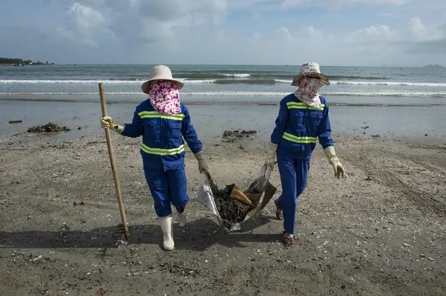 Cleaners gather debris on the beach in the central Vietnamese city of Danang on November 9, 2017 as the city gears up for the Asia-Pacific Economic Cooperation (APEC) Summit leaders meetings. (Photo by Lillian Suwanrumpha/AFP Photo)