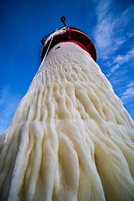 The twin lighthouses of St Joseph on Lake Michigan have been transformed by a winter storm. Ice encases the buildings, giant icicles hang from the piers and the beach is frosted white. Here: A mixture of snow and ice create mesmerising patterns on the lake facing side of South Haven lighthouse. (Photo by Mike Kline/Barcroft Media)