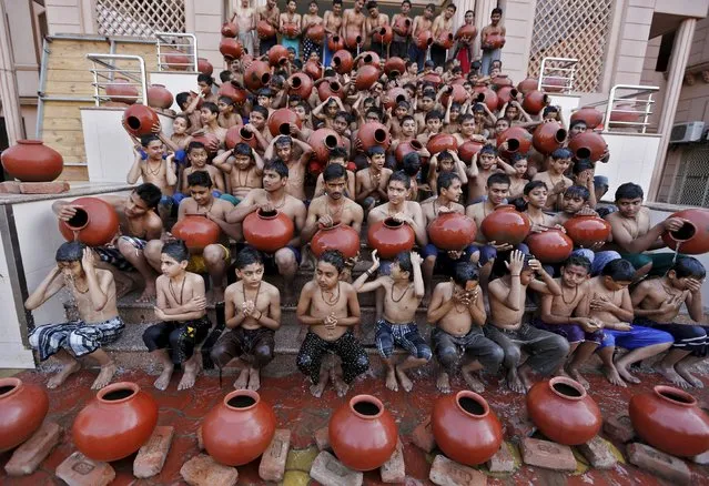 Students hold earthen pitchers filled with water as they take a holy bath ahead of the Magh Mela festival during a ceremony in Ahmedabad, India, January 22, 2016. The ceremony was organised to resemble the annual month-long religious festival held during the Hindu month of Magh, when thousands of Hindu devotees take a holy dip in the waters of the Sangam, the confluence of the rivers Ganga, Yamuna and Saraswati, in Allahabad. (Photo by Amit Dave/Reuters)