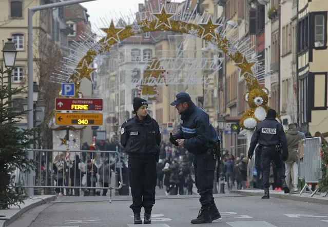 French police stand guard as tourists visit the traditional Christkindelsmaerik (Christ Child market) as emergency security measures continue during the Christmas holiday season in Strasbourg, France, December 20, 2016. (Photo by Vincent Kessler/Reuters)