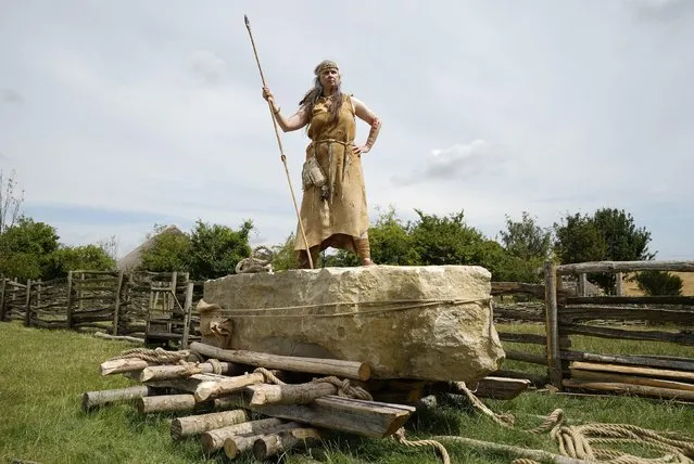 Jo Shorter, a Stone Age enthusiast and volunteer at Butser ancient farm, poses on July 27, 2022 for a photograph on top of a 3.5 ton standing stone, which is to be pulled into postion using only traditional methods, at Butser Ancient Farm to mark its 50 year anniversary. Construction at the farm, which will be ongoing over the summer, based on excavations from Danebury Iron Age Hillfort near Andover, Hampshire, will test out new theories about how roundhouses may have been constructed and reflecting and continuing the pioneering work on roundhouse construction conducted at Butser during the 1970s. (Photo by Andrew Matthews/PA Images via Getty Images)