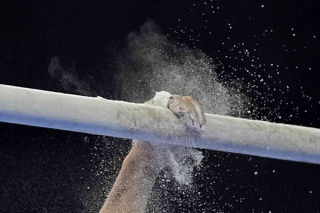 China's Boheng Zhang applies powder on the bar before competing in the Artistic Gymnastics men's parallel bars final at 19th Asian Games in Hangzhou, China, Friday, September 29, 2023. (Photo by Aijaz Rahi/AP Photo)