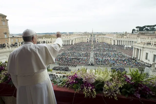 Pope Francis waves as he delivers a “Urbi et Orbi” message from the balcony overlooking St. Peter's Square at the Vatican April 5, 2015. (Photo by Osservatore Romano/Reuters)